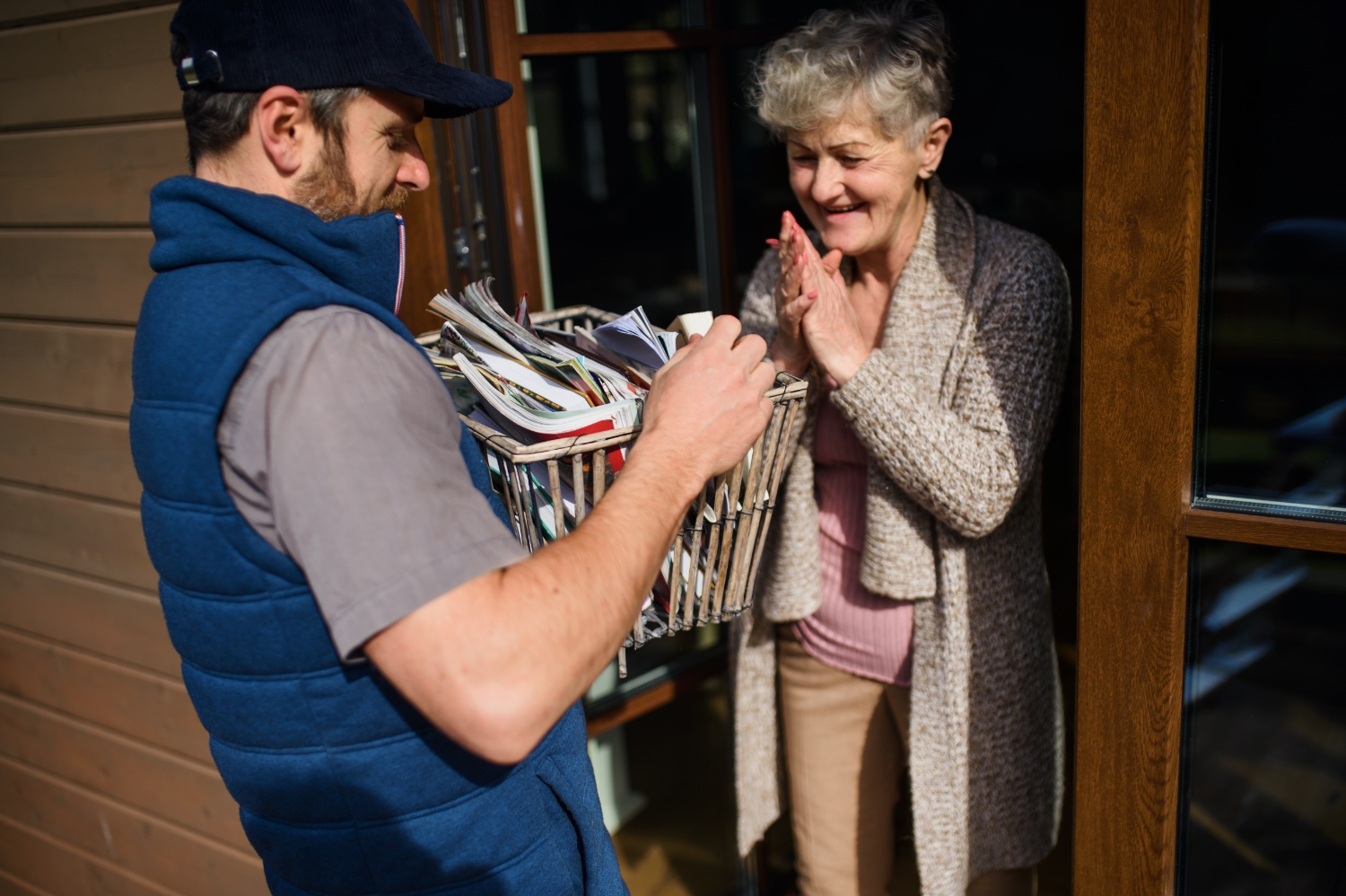 Person delivering books to older person