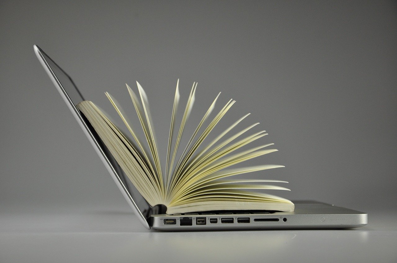 A picture of a open book on top of a laptop